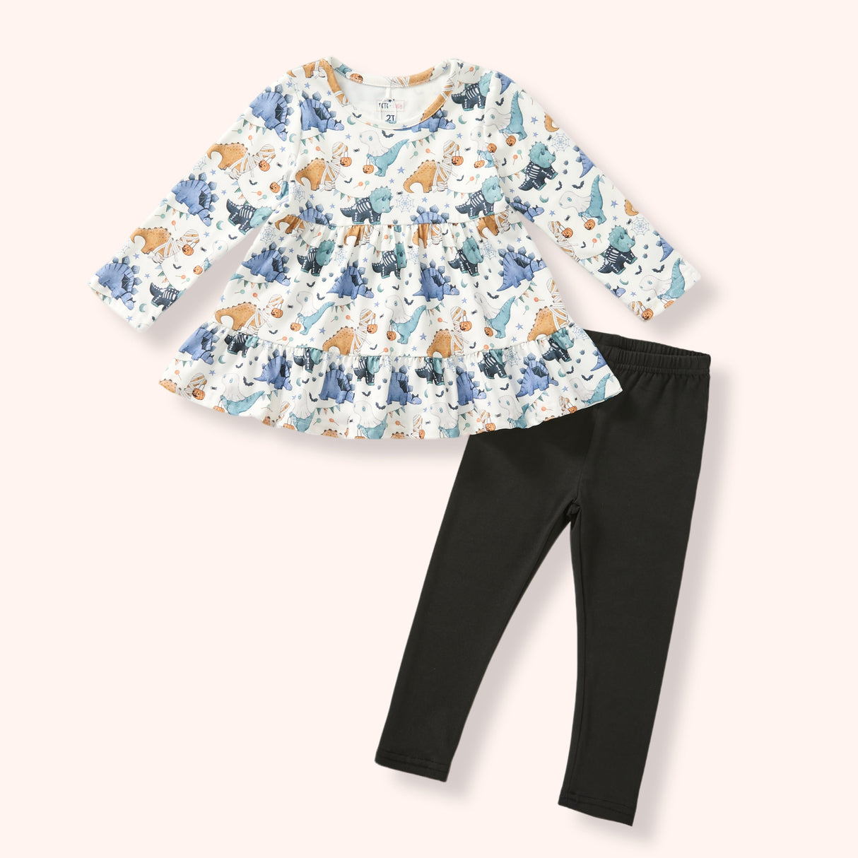 Girls cream Halloween dinosaur tunic with blue, teal and orange print paired with solid black leggings.
