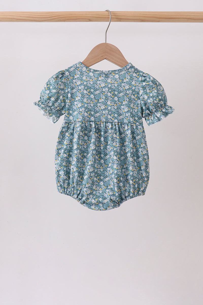 Back view of the baby bubble in a blue floral print with puff sleeves, gathered waist, and elastic leg openings.