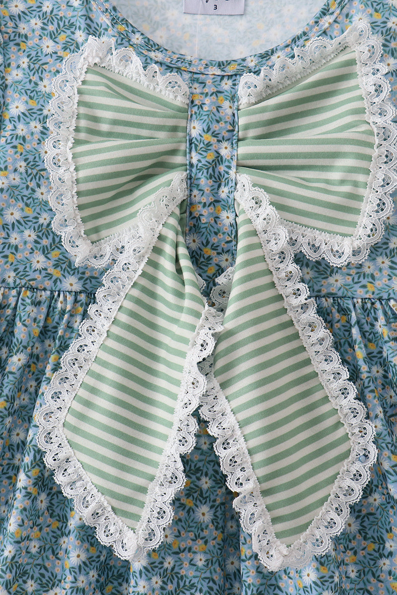 Close-up of the oversized sage-striped bow with delicate white lace trim against the blue floral dress.