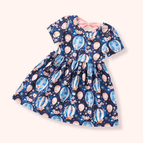 Flat lay of a navy short-sleeve dress with pastel hot air balloon and floral print.