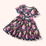 Dark short-sleeve dress with a bold floral print and tiered design, photographed flat on a light background.