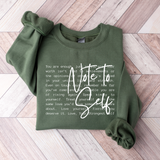 Green sweatshirt with motivational text on a wooden floor