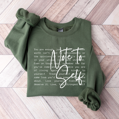 Green sweatshirt with motivational text on a wooden floor