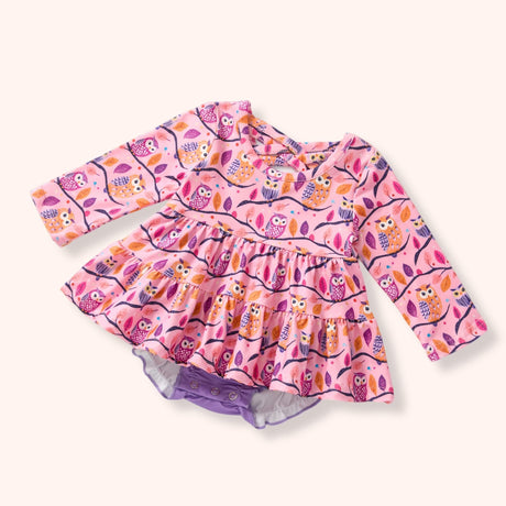 Pink owl-print skirted baby romper with long sleeves and lavender snap bottom.