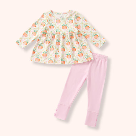 A girl's 2PC set featuring a long-sleeve cream-colored top with an orange and green pumpkin print, paired with light pink leggings with button cuffs.
