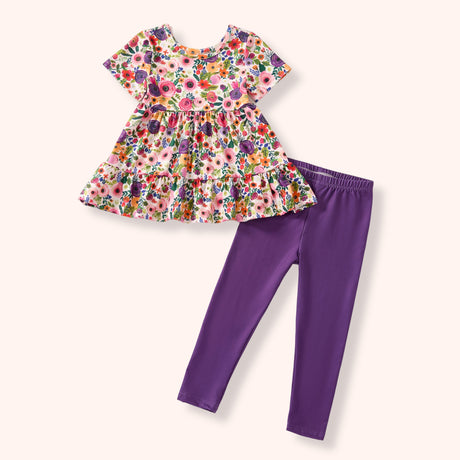 Girls floral tunic and purple leggings set with short sleeves and a ruffled hem.