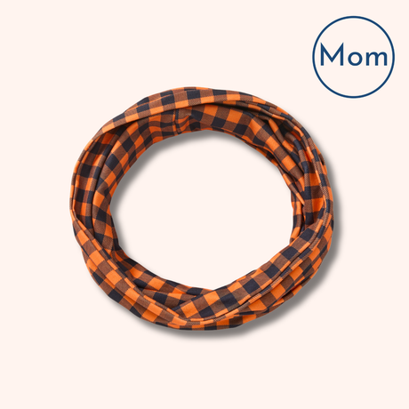 Plaid-patterned fabric scarf roll with 'Mom' label on a white background