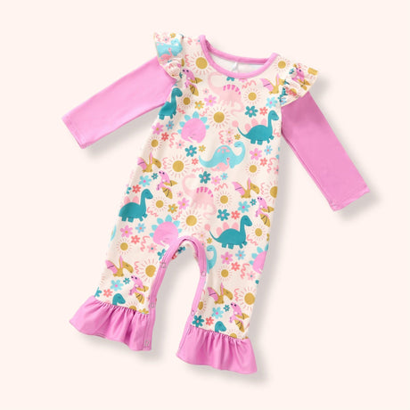 A baby long-sleeve romper with a dinosaur and floral print on a cream background, featuring solid pink sleeves and ruffled pink leg cuffs, shown on a light beige background.