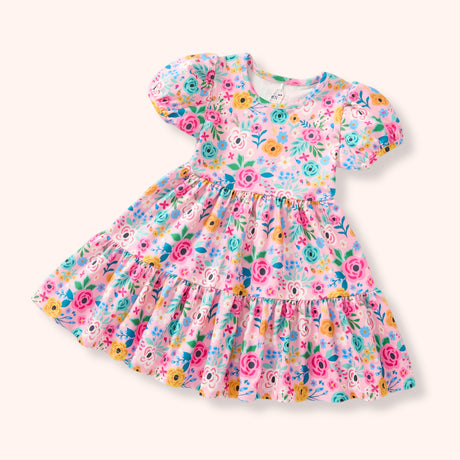Flat Lay of a short puff-sleeved pink dress with an all-over colorful floral print