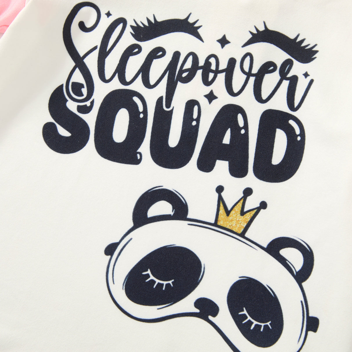 Cream pajama top graphic reading “Sleepover Squad” with sleepy eyelashes and a crowned panda sleep mask.