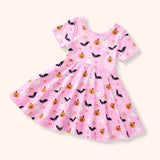 Pink children's dress with Halloween-themed pattern on a white background