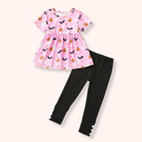 Pink Halloween-themed tunic with pumpkins and bats paired with black leggings on a white background
