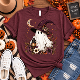 Heather maroon tee featuring a whimsical ghost in a plum witch hat holding a glowing lantern, surrounded by a crescent moon, florals, stars and fall foliage.